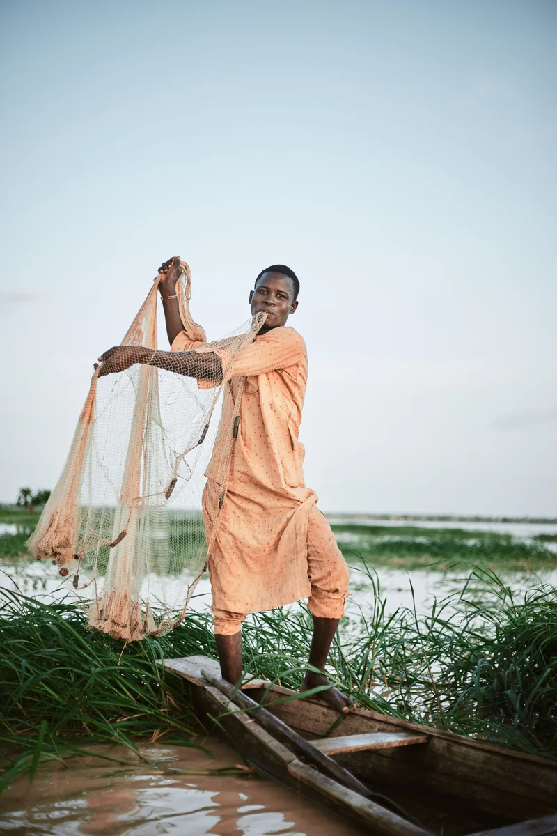 Pêcheur Tofinu lançant un filet traditionnel sur les eaux sacrées du lac Nokoué